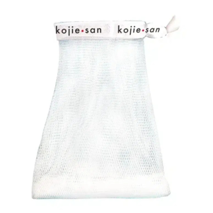 Pochette à savon en filet blanc avec fermeture à cordon sur le dessus. La bande supérieure est ornée de l'inscription « kojie.san » en lettres noires et rouges. La pochette présente une surface texturée, conçue pour contenir le savon et faire mousser. Dakar