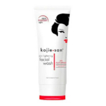 Un tube blanc de nettoyant visage éclaircissant Kojie San au design minimaliste, orné d'un visage stylisé aux accents noirs et rouges. L'étiquette mentionne « lumière zéro pigment » et « Hydromoist » comme caractéristiques principales. Dakar