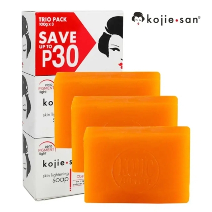 Image d'un trio de savons Kojie San. L'emballage affiche « ÉCONOMISEZ JUSQU'À 30 P » et un visage stylisé. Trois savons orange sont présentés devant la boîte, chacun imprimé du logo Kojie San. Dakar