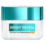 Un petit récipient blanc avec un couvercle bleu sarcelle étiqueté « BRIGHT REVEAL » avec « Dark Spot Feuchtigkeitspflege LSF 50 » indiquant un produit de soin de la peau. Dakar