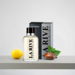 Un flacon de parfum La Rive Grey Point est exposé devant son coffret. À côté, un citron et une cabosse de cacao aux feuilles vertes sont posés sur une étagère, suggérant les ingrédients du parfum. Le fond est épuré et minimaliste. Dakar
