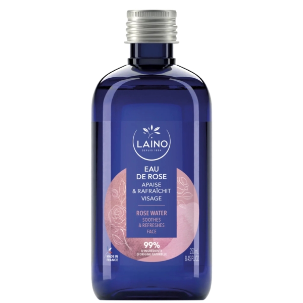 Une bouteille bleue d'eau de rose Laino est présentée avec l'étiquette « Eau de Rose, Apaise et Rafraîchit Visage, Eau de Rose, Apaise et Rafraîchit Visage ». L'étiquette indique qu'elle est fabriquée en France et contient 99 % d'ingrédients d'origine naturelle. Contenance : 250 ml. Dakar