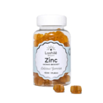 Un flacon transparent étiqueté « Lashilé Beauty Zinc Mono Boost » contient des compléments alimentaires gélifiés orange. L'étiquette indique également « Délicieux Gummies » et « Vegan », avec une mention indiquant 60 gélifiés à l'intérieur. Quelques gélifiés sont placés devant le flacon. Dakar