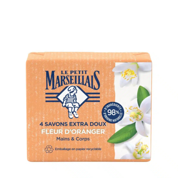 Emballage de savon orange étiqueté « Le Petit Marseillais » avec un petit personnage. L'inscription « 4 savons extra doux, Fleur d'Oranger, Mains & Corps » y est inscrite. Contient des fleurs d'oranger blanches et revendique 98 % d'origine naturelle. Emballage en papier recyclable. Dakar