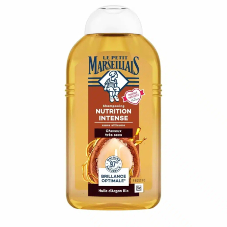 Un flacon de shampoing Le Petit Marseillais Nutrition Intense pour cheveux très secs, à l'huile d'argan. L'emballage mentionne « 97 % d'ingrédients d'origine naturelle » et « Argan Bio », avec un sceau représentant une femme en tenue traditionnelle. Dakar