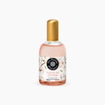 Un flacon d'eau de toilette « Les Petits Plaisirs », étiqueté « Fleur de Coton ». Le flacon est doté d'un bouchon doré et l'emballage présente un motif de fleurs de coton. Dakar