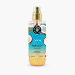 Un flacon pulvérisateur de brume corps et cheveux Coco « Les Petits Plaisirs » est présenté. L'étiquette présente des images de noix de coco et indique qu'il est sans alcool. Le flacon est doté d'un embout doré et d'un liquide transparent à l'intérieur. Dakar