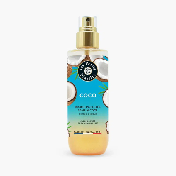 Un flacon pulvérisateur de brume corps et cheveux Coco « Les Petits Plaisirs » est présenté. L'étiquette présente des images de noix de coco et indique qu'il est sans alcool. Le flacon est doté d'un embout doré et d'un liquide transparent à l'intérieur. Dakar