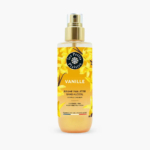 Un flacon de brume corps et cheveux parfumée à la vanille « Les Petits Plaisirs ». Le flacon est orné de fleurs de vanille jaunes et doté d'un vaporisateur doré. L'étiquette indique qu'il est sans alcool et fabriqué en France. Dakar