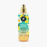 Un vaporisateur de brume corps et cheveux Vanille Monoï Les Petits Plaisirs. Le flacon arbore un motif floral tropical composé de fleurs jaunes et blanches. L'étiquette indique qu'il est sans alcool et fabriqué en France. Dakar