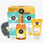Coffret cadeau comprenant un gel douche, une crème pour les mains, un lait pour le corps, une eau de toilette et un chouchou. Chaque produit est étiqueté « Les Petits Plaisirs » avec un parfum vanille et monoï. L'emballage est jaune et bleu sarcelle, avec des motifs floraux. Dakar