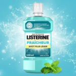 Un flacon de bain de bouche Listerine de 500 ml portant l'inscription « FRAÎCHEUR GOÛT PLUS LÉGER SANS ALCOOL ». Le liquide mentholé est mis en valeur sur un fond éclaboussé, avec des feuilles de menthe en bas à droite, soulignant la fraîcheur. Dakar
