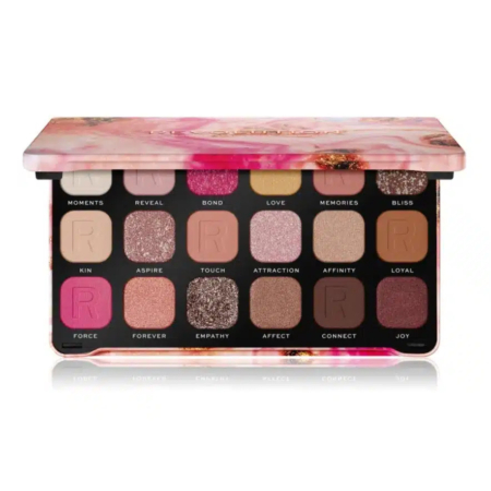 Une palette de maquillage proposant 18 teintes variées, dont des roses, des bruns et des tons chatoyants. Le couvercle est orné d'un motif floral. Un pinceau à double embout est placé devant la palette. Dakar