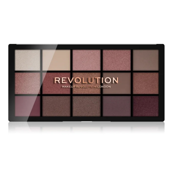 Une palette de maquillage composée de 15 fards à paupières aux tons neutres et bruns variés, disposés en trois rangées de cinq. Le logo « Revolution » est imprimé au centre en lettres dorées. Dakar