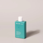 Un flacon bleu sarcelle de gel douche Medix 5.5 à l'acide glycolique et lactique, conçu pour sublimer la peau. Son bouchon blanc se détache sur un fond neutre. Dakar