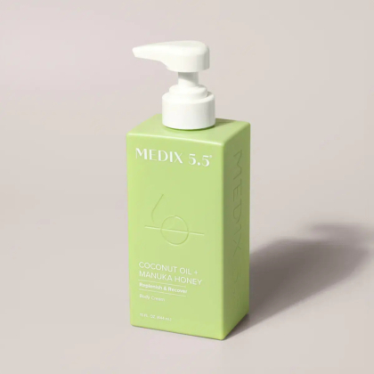 Bouteille rectangulaire verte avec une pompe blanche, étiquetée « MEDIX 5.5 » et « Crème pour le corps à l'huile de coco + miel de Manuka, régénérante et régénérante, 15 oz liq. (443 ml). Dakar