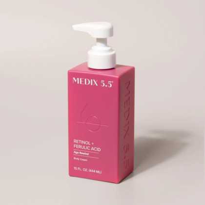 Un flacon rectangulaire rose de crème pour le corps Medix 5.5 avec pompe. L'étiquette sur le devant indique « Rétinol + Acide férulique, Age Rewind, Crème pour le corps, 444 ml ». Dakar