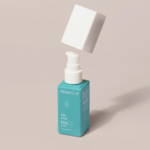 Un flacon bleu sarcelle étiqueté « MEDIX 5.5 » et portant la mention « Sérum Rénovateur 10 % AHA » est présenté avec son bouchon blanc flottant au-dessus. Le flacon projette une ombre sur un fond clair et neutre. Dakar