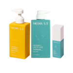 Trois produits de soin de la peau de Medix 5.5 sont présentés : une crème corporelle jaune à la vitamine C + curcuma, un gel douche bleu à l'acide glycolique + lactique et un sérum affinant bleu clair à 10 % d'AHA. Dakar