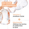 Gros plan de gouttes liquides claires avec le texte en français : "Duo d'actifs complémentaires. Vitamine C : Améliore l'éclat. Niacinamide : Atténue les taches et uniformise le teint." Découvrez Mixa Crème de Soin Spf50 Niacinamide Bright Anti Taches 50 ml pour une protection solaire optimale. Dakar