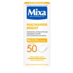 La Crème de Soin Mixa SPF50 Niacinamide Bright Anti Taches 50 ml est une crème protectrice pour peaux sèches, dotée d'un SPF 50. Elle est enrichie en glycérine (9 %), niacinamide et vitamine E. Le texte sur sa boîte blanche et jaune est en allemand et en français. Dakar