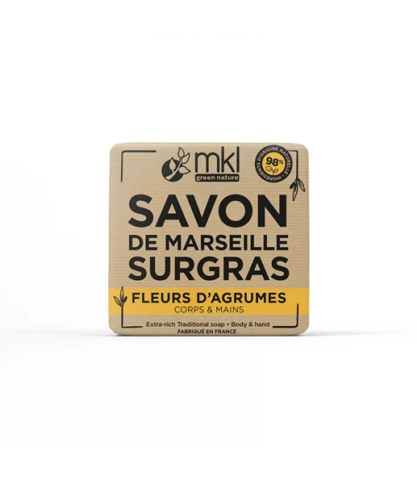 Un pain de savon carré MKL Green Nature, étiqueté « Savon de Marseille Surgras » et « Fleurs d'Agrumes », pour le corps et les mains. Son emballage beige avec inscription noire et jaune indique qu'il est d'origine naturelle à 98 % et fabriqué en France. Dakar