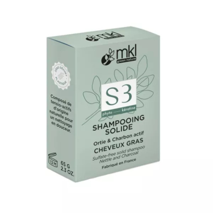 Une boîte verte de shampoing solide MKL Green Nature, étiqueté S3 à l'ortie et au charbon pour cheveux gras. Le texte mentionne : sans sulfate, phyto, kératine, et fabriqué en France, pesant 65 g. Dakar