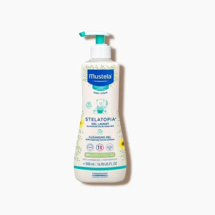 Un flacon de gel lavant Mustela Stelatopia pour bébé, muni d'une pompe. Blanc avec des touches de bleu et de vert, il est orné d'illustrations de plantes et d'un ourson. L'étiquette indique qu'il est adapté aux peaux sensibles et contient 500 ml. Dakar