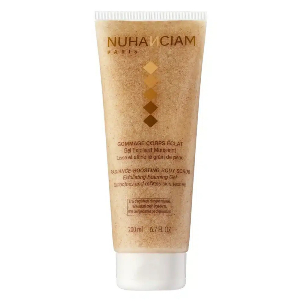 Tube de Gommage Corps Éclat Nuhanciam Paris. L'emballage est beige avec des touches dorées et blanches. L'étiquette met en valeur ses propriétés exfoliantes et éclatantes, conçues pour lisser et affiner le grain de peau. Contenance : 200 ml. Dakar