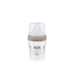 Biberon transparent au design beige, orné du mot « NUK » imprimé au centre, orné de motifs floraux et d'un cœur. Doté d'un grand bouchon et d'une base large, il se détache sur un fond blanc uni. Dakar