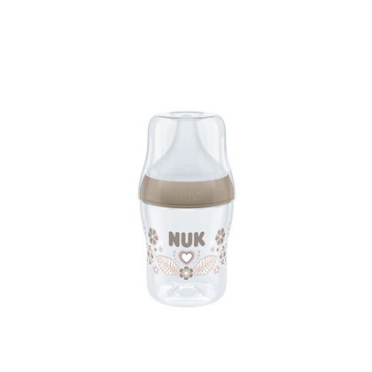 Biberon transparent au design beige, orné du mot « NUK » imprimé au centre, orné de motifs floraux et d'un cœur. Doté d'un grand bouchon et d'une base large, il se détache sur un fond blanc uni. Dakar