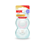 Un emballage contenant une sucette NUK Star en silicone pour les bébés de 0 à 2 mois. L'emballage est principalement blanc avec des touches de jaune et de rouge. La sucette est visible, ornée d'un cœur et de l'inscription « Ma première NUK ». Dakar