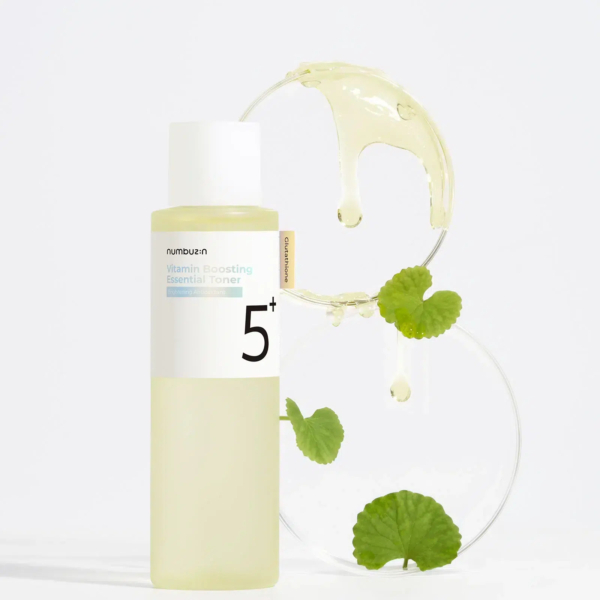 Un flacon de tonique essentiel Vita B Boosting Numéro 3 est présenté sur fond blanc. Le flacon est jaune clair avec un bouchon blanc. Derrière lui, deux disques transparents ornés de feuilles vertes et de gouttes de liquide sont disposés de manière artistique. Dakar