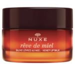 Un pot de baume à lèvres au miel Rêve de Miel de Nuxe Paris avec un couvercle marron foncé. Le contenant en verre présente une couleur ambrée dégradée et un texte blanc. Dakar