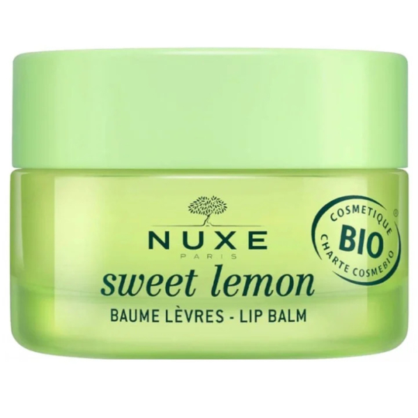 Un pot vert étiqueté « Nuxe Paris Sweet Lemon Baume Lèvres » et orné du logo « Bio Cosmétique ». Le pot est doté d'un couvercle vert clair et d'un corps transparent, laissant apparaître une substance jaune pastel à l'intérieur. Dakar
