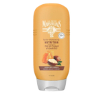 Flacon orange de l'après-shampooing Le Petit Marseillais. L'étiquette indique « Après-shampooing Nutrition, Miel de Provence et Karité Bio ». Image de nid d'abeille et de noix de karité. Conçu pour les cheveux secs et cassants. Contient 95% d'ingrédients d'origine naturelle. Dakar