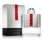 Un flacon d'Eau de Toilette Prada Luna Rossa en verre métallisé et transparent est présenté à côté de son coffret gris assorti. Tous deux présentent des touches de rouge et le nom de la marque est bien visible. Dakar