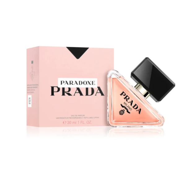 Un flacon de 30 ml d'Eau de Parfum Prada Paradoxe, présenté dans un coffret rose. Le flacon est triangulaire, avec un bouchon noir et une étiquette logo Prada. Le coffret est rose clair avec un texte noir. Dakar