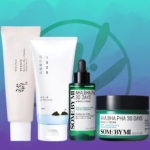 Découvrez la collection Routine ANTI IMPERFECTIONS : PEAU GRASSE à SENSIBLES sur fond dégradé bleu-vert. Comprend un tube blanc avec texte rouge, un tube plus grand avec graphisme bleu et vert, un flacon compte-gouttes vert et un pot vert-blanc du Trio Cosrx. Dakar