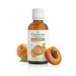 Un flacon d'huile végétale de noyaux d'abricot Puressentiel est présenté, entouré d'abricots. L'étiquette indique qu'il est 100 % pur et naturel, et que le produit est certifié biologique. Le flacon et le fruit se reflètent sur la surface blanche. Dakar