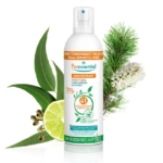 Un flacon de Spray Purifiant Aérien Puressentiel au bouchon blanc est entouré d'ingrédients naturels comme une tranche de citron vert, des aiguilles de pin et une branche d'eucalyptus. L'étiquette indique « 41 huiles essentielles » et « 100 ml offerts ». Dakar