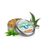 Une boîte métallique étiquetée « Gouttes Respiratoires » s'ouvre pour révéler des pastilles rondes couleur caramel. La boîte est entourée de brins de menthe et de feuilles d'eucalyptus. L'étiquette mentionne des ingrédients comme le menthol et l'eucalyptus, et affirme que le produit apaise la gorge. Dakar
