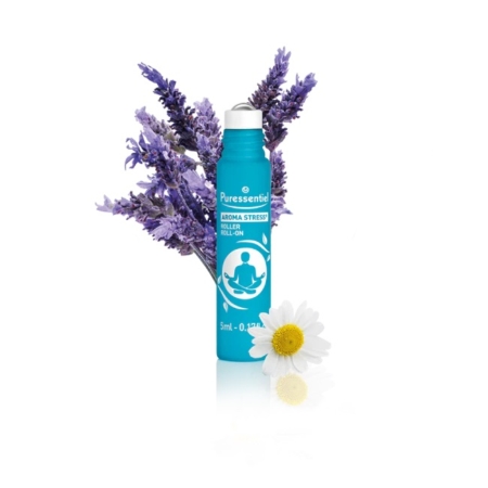 Un flacon roll-on bleu, étiqueté « Puressentiel Aroma Stress », est entouré de brins de lavande violette. Une fleur de camomille blanche est placée à sa base. Ce roll-on est conçu pour soulager le stress. Dakar
