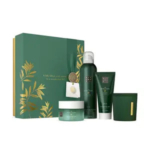 Un coffret cadeau de soins de la peau vert avec des accents dorés, comprenant une boîte, un pot, une bouteille, un tube et une bougie, présentés sur un fond blanc. Dakar