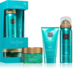 Un coffret de produits Rituals Karma comprend un trio, un pot de gommage, un tube de crème pour le corps et un flacon de gel douche moussant. Tous les articles sont turquoise avec des touches argentées et arborent le logo Rituals. Dakar