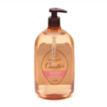 Un flacon pompe en plastique marron étiqueté « Cavaillès Huile de Douche Satinante » pour peaux sensibles. L'étiquette présente une petite zone rose et la mention « Argan Bio ». Le flacon est placé sur un fond blanc uni. Dakar