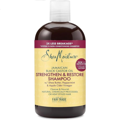 Flacon de shampoing fortifiant et réparateur à l'huile de ricin noire jamaïcaine Shea Moisture. L'étiquette souligne « 3 fois moins de casse » et contient des ingrédients comme le beurre de karité, la menthe poivrée et le vinaigre de cidre. Il promet de nettoyer et de nourrir les cheveux naturels et traités chimiquement. Dakar