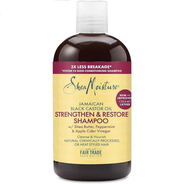 Flacon de shampoing fortifiant et réparateur à l'huile de ricin noire jamaïcaine Shea Moisture. L'étiquette souligne « 3 fois moins de casse » et contient des ingrédients comme le beurre de karité, la menthe poivrée et le vinaigre de cidre. Il promet de nettoyer et de nourrir les cheveux naturels et traités chimiquement. Dakar