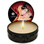 Une bougie allumée dans une boîte noire aux motifs complexes. Le couvercle est ouvert, laissant apparaître une œuvre d'art représentant un couple. L'étiquette indique « Shunga Erotic Art » et « Strawberry Wine Massage Candle ». Dakar