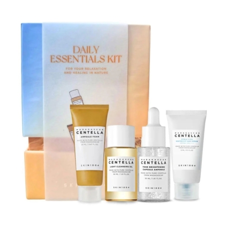 Le coffret Skin1004 Daily Essentials Kit Routine de Soins Complète présente quatre produits de soins de la peau exquis : une mousse en ampoule, une huile nettoyante légère, un sérum et une crème éclaircissante, tous élégamment disposés avant l'emballage du kit. Dakar